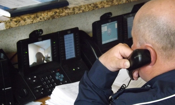 Policjant na stanowisku oficera dyżurnego KPP Dębica, odbiera telefoniczne zgłoszenie.