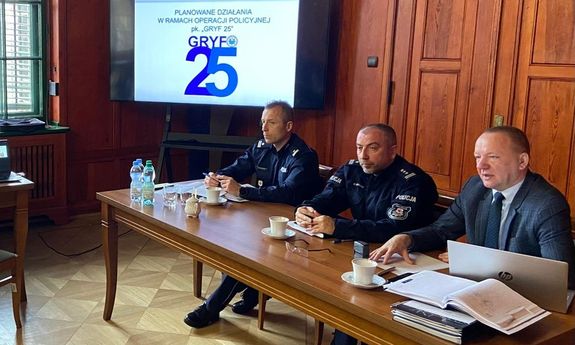 Uczestnicy spotkania roboczego siedzą na krzesłach za stołem.