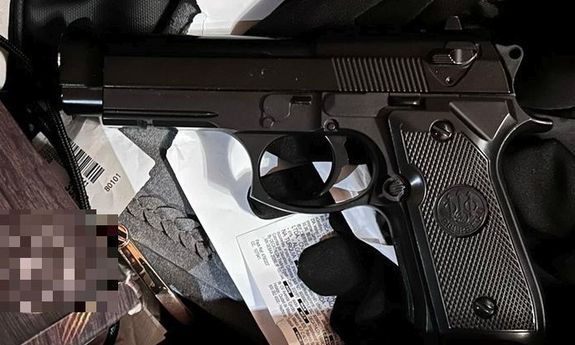 Leżący na stole pistolet.