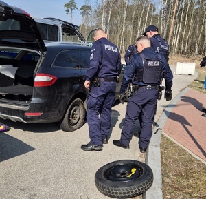 Policjanci pomagają zmienić koło.