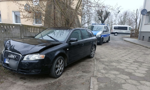 Uszkodzony pojazd, za nim stoi radiowóz.