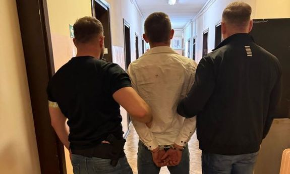 dwóch policjantów stoi z zatrzymanym.
