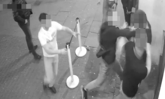 Stopklatka z nagrania monitoringu przedstawia grupę ludzi w trakcie bójki.