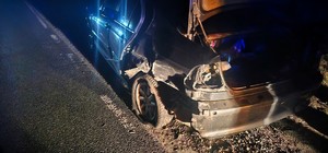 Widok na uszkodzony pojazd i brak koła w samochodzie.