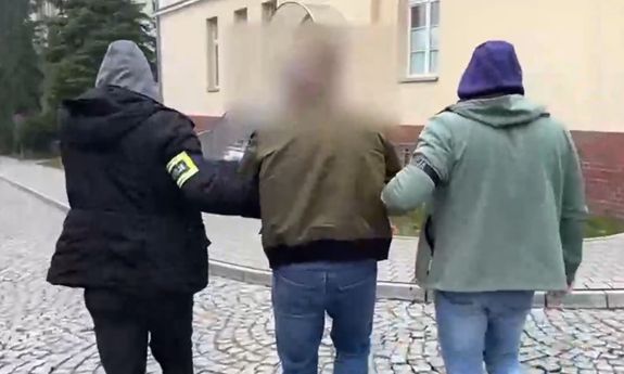 Dwaj nieumundurowani policjanci prowadzą zatrzymanego. Widok z tyłu.