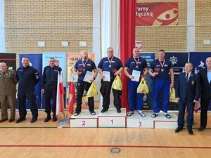 Policjanci na podium i obok pozują do zdjęcia.