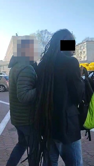 Zatrzymany mężczyzna z funkcjonariuszami.