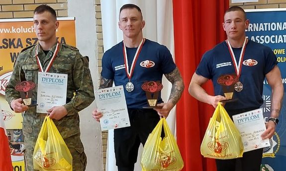 trzech mężczyzn stoi na podium.
