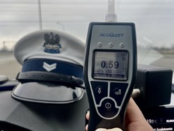 Alkomat oraz czapka policjanta ruchu drogowego w samochodzie na desce rozdzielczej.