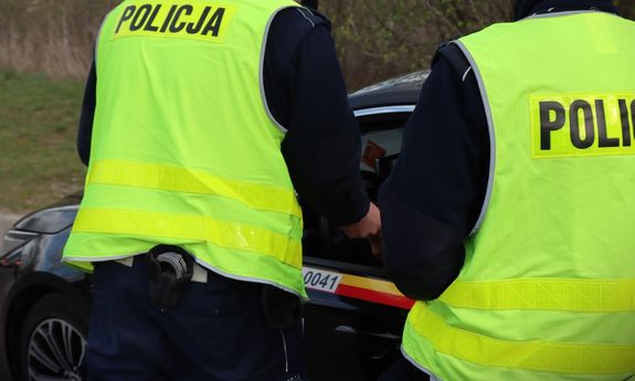 dwóch policjantów sprawdza taksówkarza.