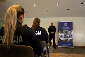policjant stoi przodem do słuchających.