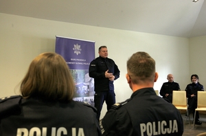 policjant stoi przodem do słuchających.