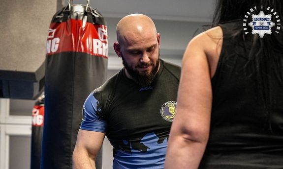 Nieumundurowany policjant szkoli ratowniczkę medyczną.