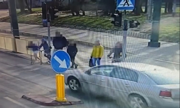 Samochód wjeżdżający na przejście dla pieszych, na które wchodza piesi.
