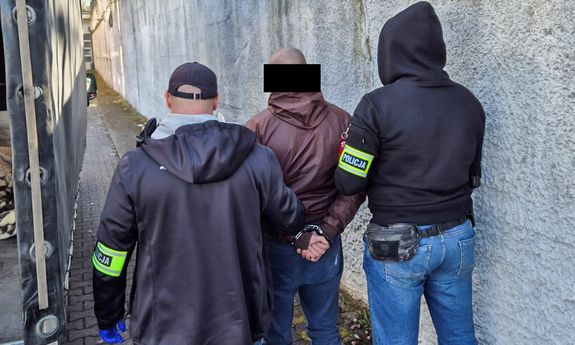 dwóch policjantów stoi z zatrzymanym.