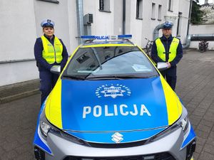 Policjanci, którzy wzięli udział w pilotażu stoją przy radiowozie.