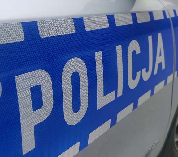 Fragment policyjnego radiowozu z napisem Policja.