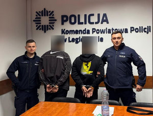 policjanci stoją z zatrzymanym.