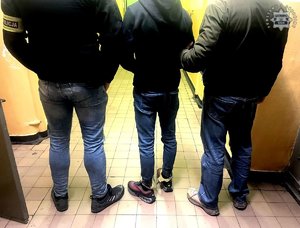 Policjanci prowadza zatrzymanego.