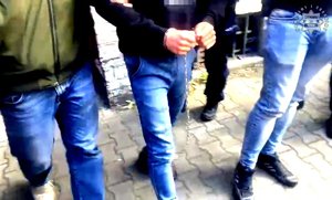 Policjanci prowadza zatrzymanego.