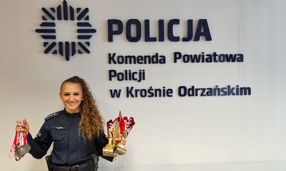 Umundurowana policjantka pozuje do zdjęcia ze zdobytym pucharem.
