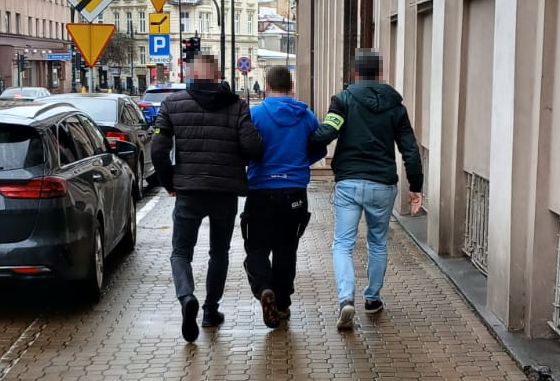zatrzymany mężczyzna w kajdankach z dwoma policjantami