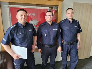 Trzej umundurowani policjanci pozują do zdjęcia.
