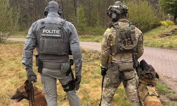 policjant z Holandii stoi obok policjanta z Polski. towarzyszą im dwa psy.