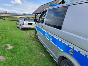 z przodu stoi zatrzymany samochód, z tyłu stoi radiowóz.