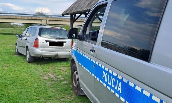 z przodu stoi zatrzymany samochód, z tyłu stoi radiowóz.