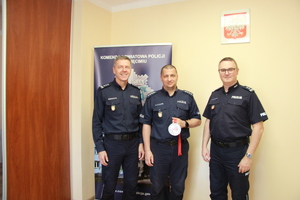 Komendanci KPP Oświęcim z Krzysztofem Teper, który trzyma medal.