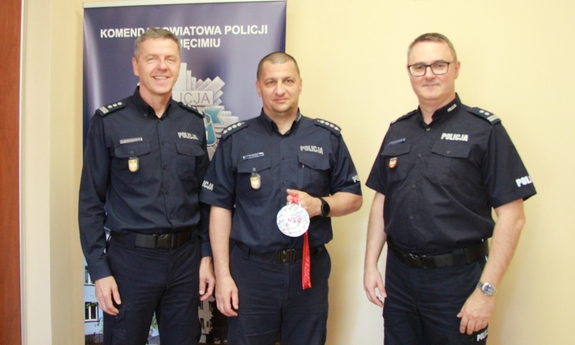 Komendanci KPP Oświęcim z Krzysztofem Teper, który trzyma medal.