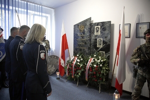Umundurowani funkcjonariusze oddają hołd poległemu policjantowi.