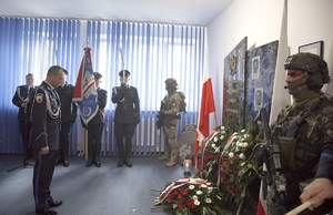 Umundurowany funkcjonariusz oddaje hołd poległemu policjantowi.