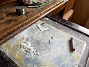 Narkotyki wysypane na stole a obok tekturowy rulonik.