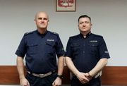 Dwaj umundurowani policjanci stoją obok siebie i pozują do zdjęcia.