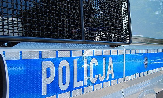 Napis Policja na drzwiach radiowozu policyjnego.