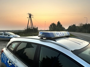 Dwa radiowozy policyjne stojące przy drodze.