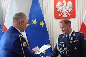 Wręczanie medalu policjantowi.