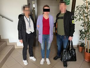 Dwaj funkcjonariusze z zatrzymaną osobą.