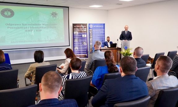 sala. na ścianie widać prezentację. oglądają ją siedzący tyłem do aparatu uczestnicy szkolenia.