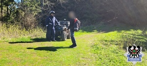 Policjant stoi przy quadzie, obok mężczyzna.