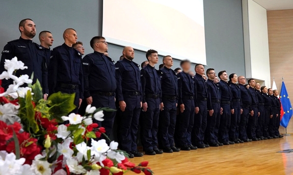 Grupa policjantów stojąca w dwuszeregu podczas uroczystości.