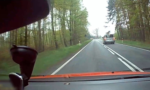 Widok przez przednią szybę samochodu na drogę.