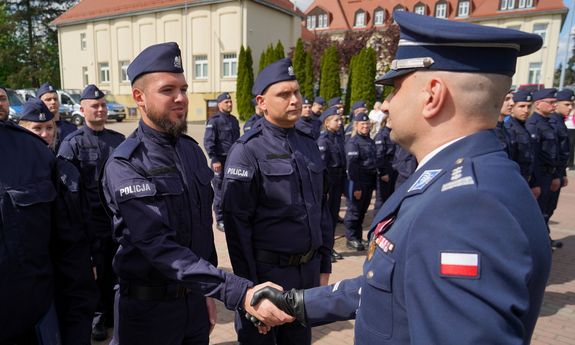 policjant podaje rękę innemu policjantowi.