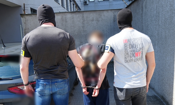 Dwaj policjanci z zatrzymanym mężczyzną.