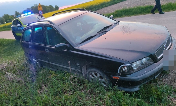 Samochód z poboczu, za nim stoi radiowóz.