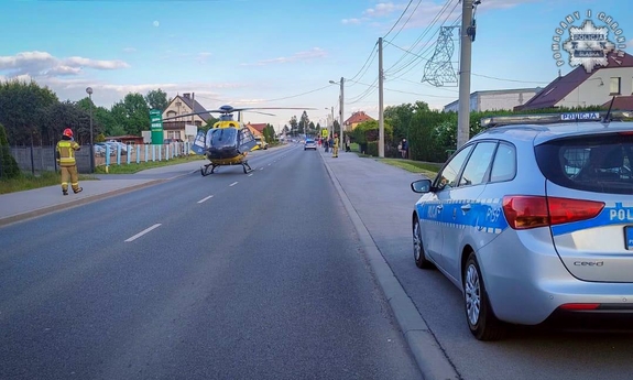 Miejsce wypadku drogowego. Na drodze stoi śmigłowiec pogotowia ratunkowego, obok radiowóz.