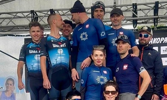Zawodnicy pozują do zdjęcia stojąc na podium.