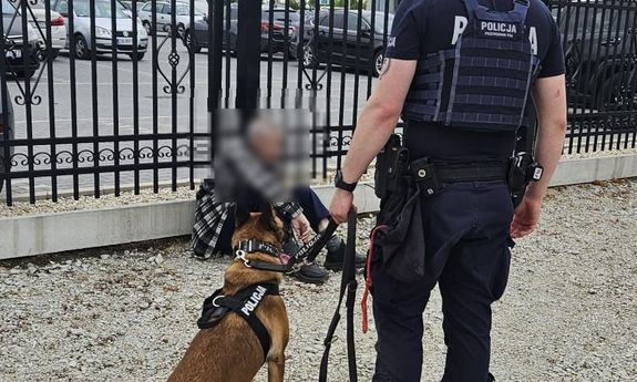 policjant z psem policyjnym stoją obok zaginionego.
